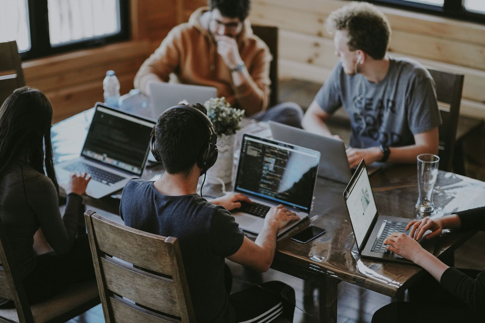 A software team collaborating on laptops around a shared table